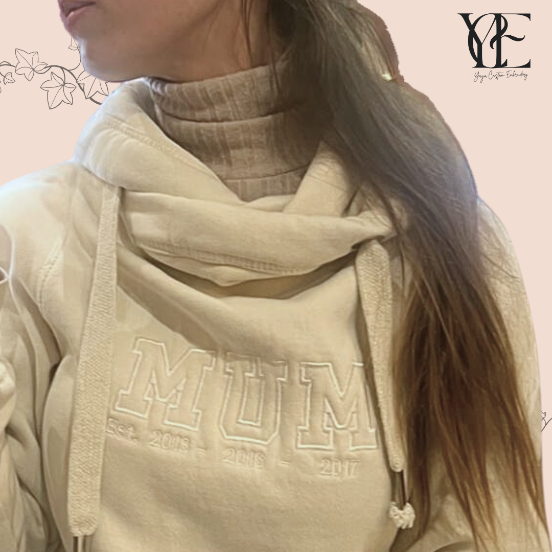 tone-on-tone embroidery of the word MUM over a vanilla hoodie.