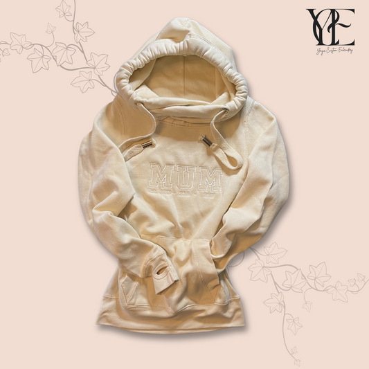 Full size photo of a vanilla colour hoodie embroidered over the chest with the word "MUM" and the "Est." year under it