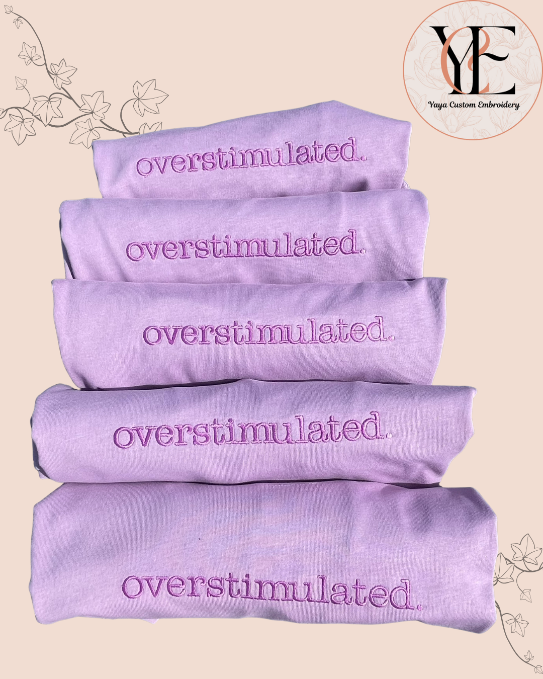 Stack of overstimulated embroidery on lavender T-shirts