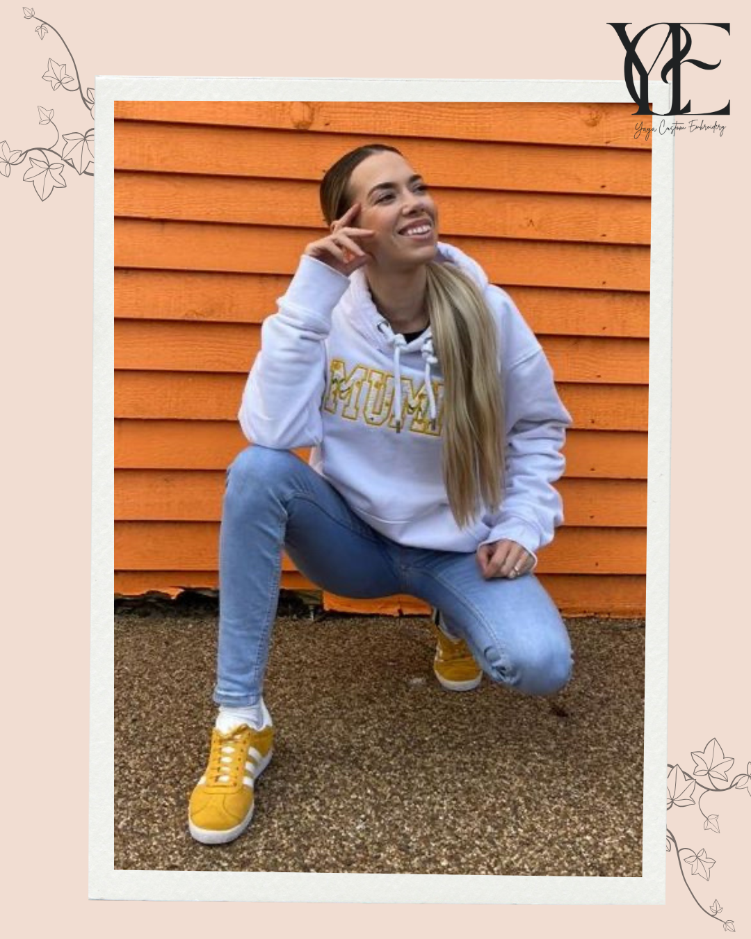 Girl wearing a white hoodie with the word MUMMY embroidered in yellow using Varsity Font