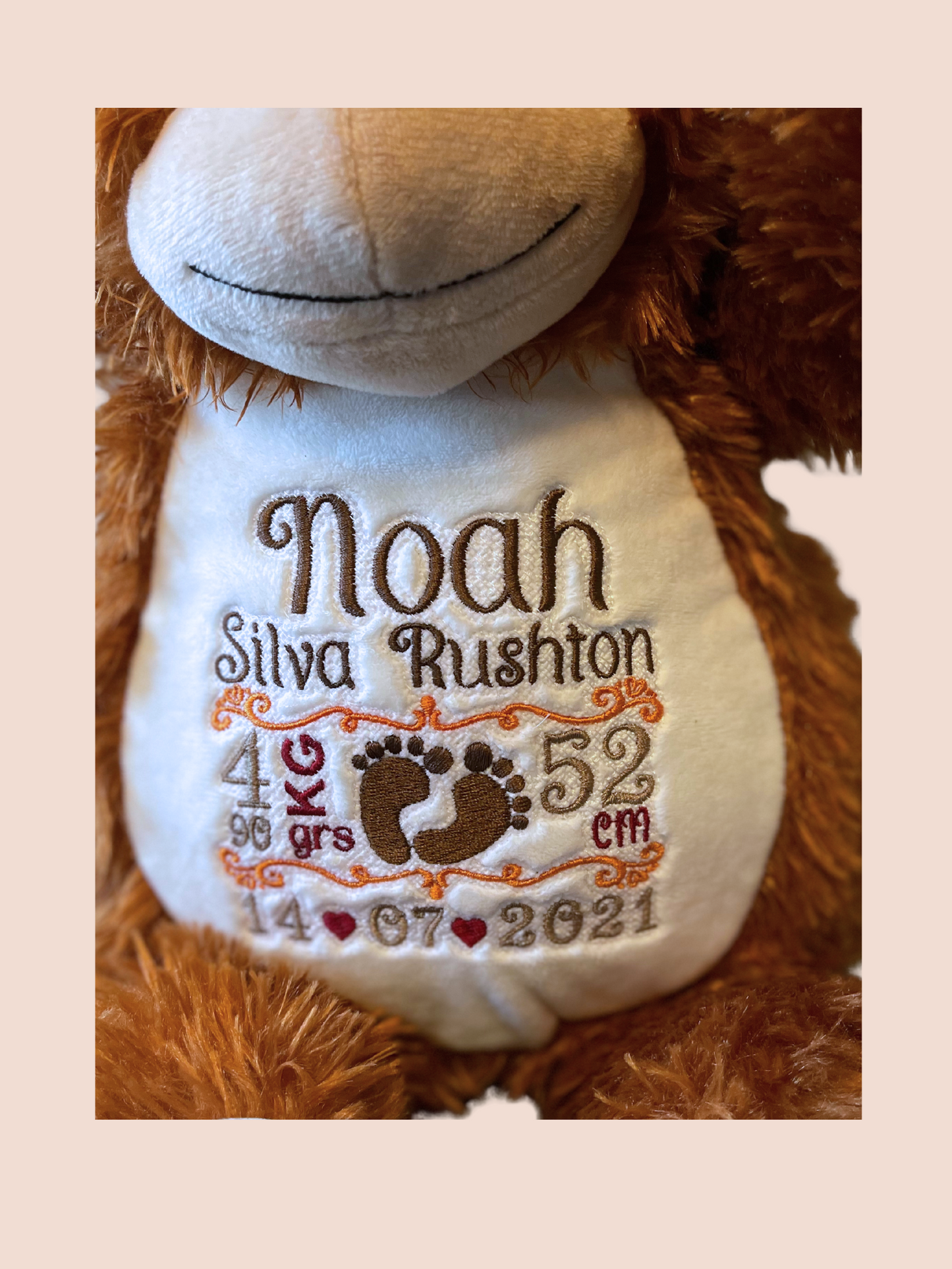 Embroidered soft toy. Close up of details of the new born baby embroidered on the orangutan soft toy.