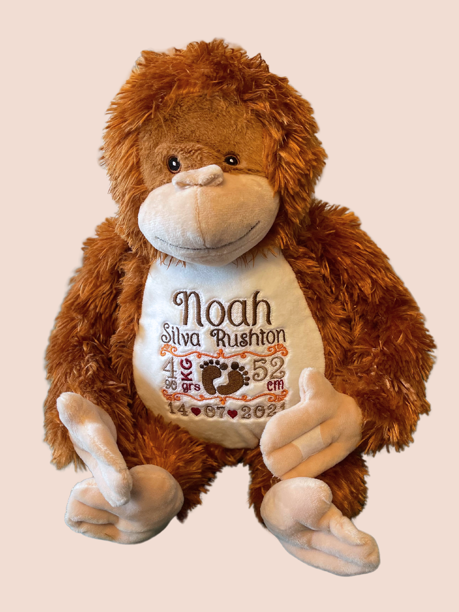 Orangutan soft toy displaying on his belly the embroidered details of a new born. Details are full name, weight, length and date of birth.