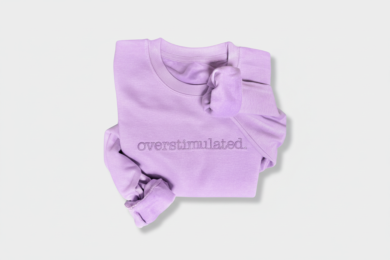 Lavender sweatshirt with 'overstimulated' text on a white background