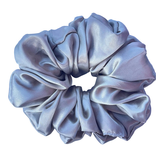 A single satin hair scrunchie in a light silver-gray color, photographed flat on a white e fabric background.