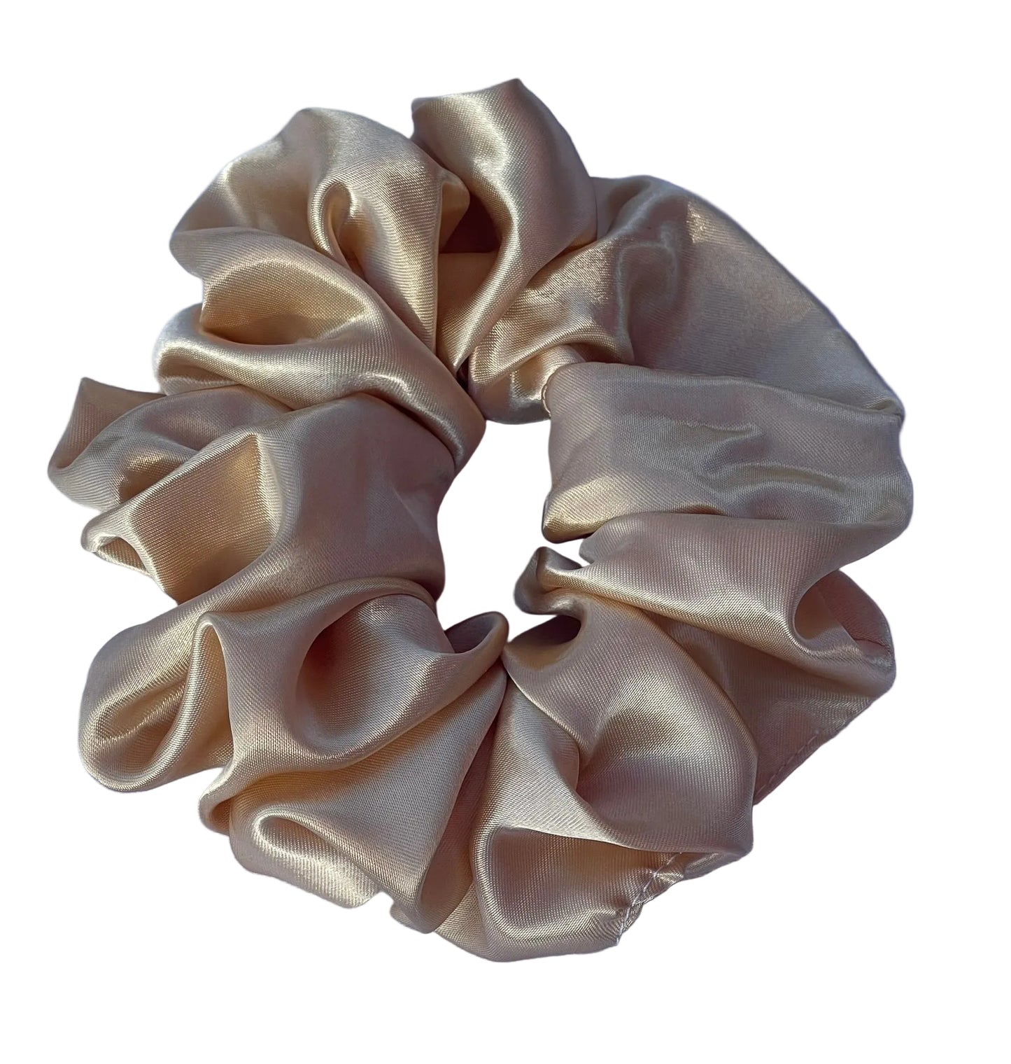A gold satin hair scrunchie with a glossy, texture, displayed on a white fabric background.