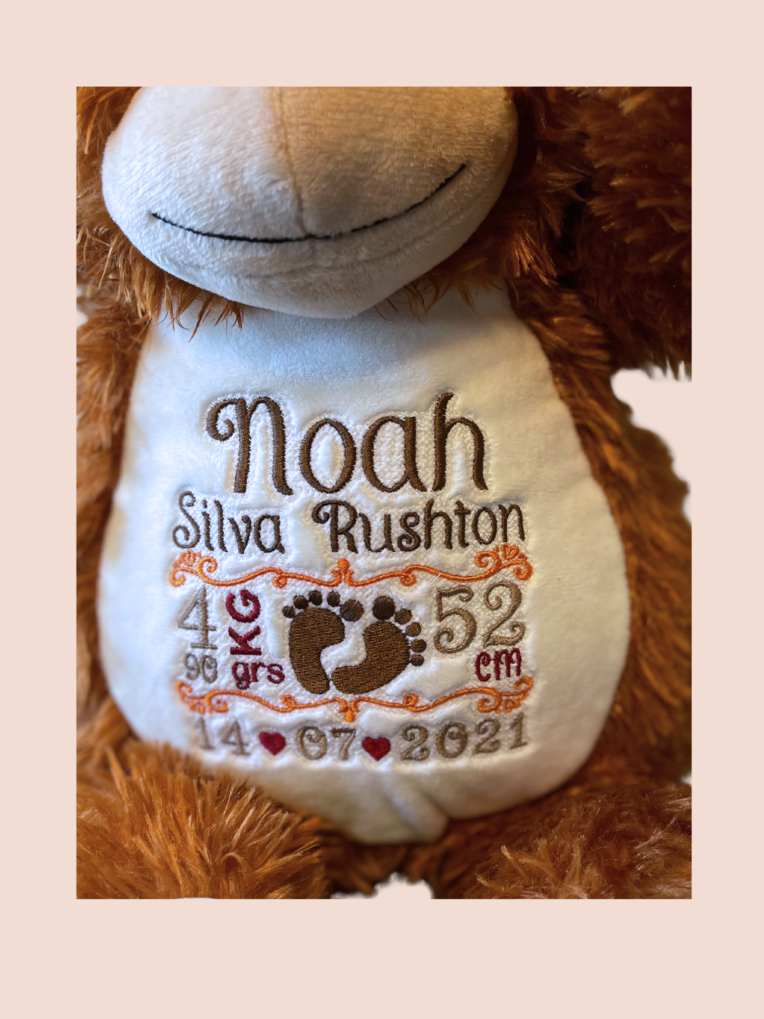 Close up of details of the new born baby embroidered on the orangutan soft toy.