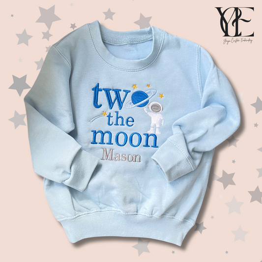 Personalised blue sweatshirt with "Two the moon" embroidered along with an astronaut and "Mason", the child's name