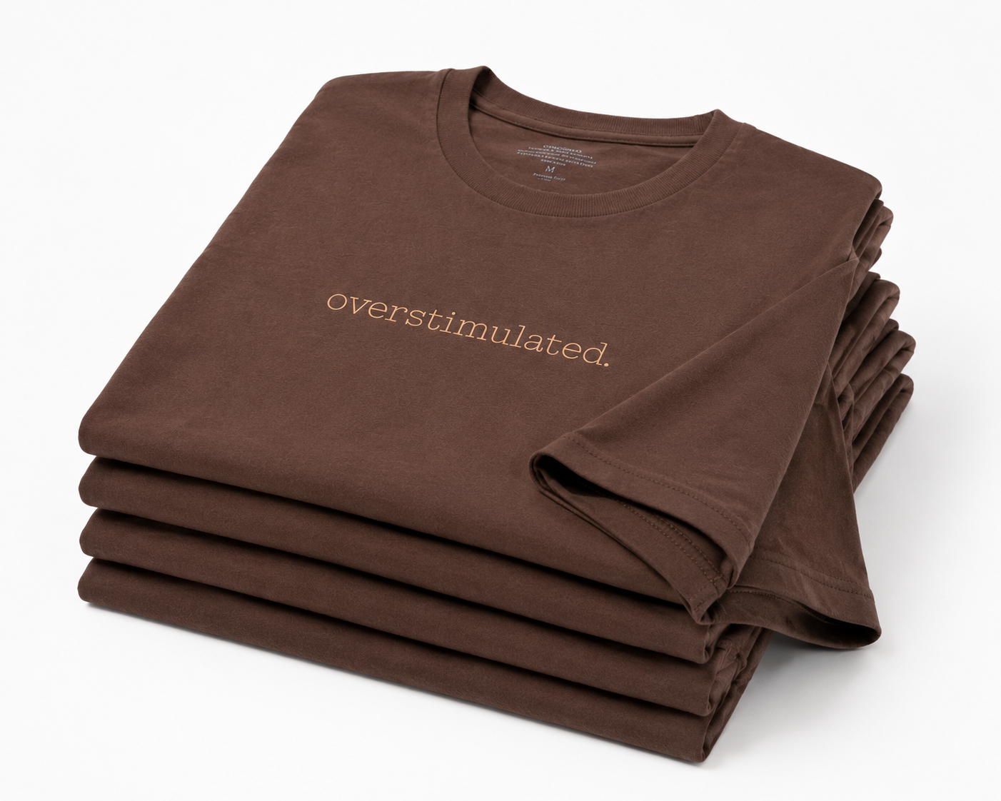 pile of folded  chocolate brown T-shirts with the embroidery "overstimulated"  across the chest