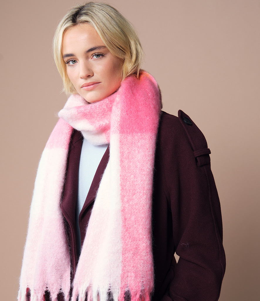 Woman wearing a pink check scarf against a beige background